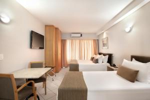 圣保罗美国阁楼广场酒店的酒店客房设有两张床和一张桌子。