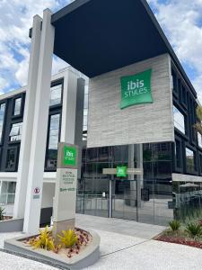 波苏斯-迪卡尔达斯ibis Styles Poços de Caldas的前面有灯泡标志的建筑