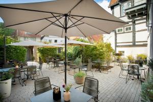 代特莫尔德Wertschätzer Hotel - Krumme Str的一个带桌椅和遮阳伞的庭院