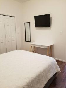 凤凰城Tiny home rentals near Ft Moore的一间卧室配有一张床、一张书桌和一台电视