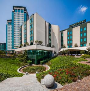 维梅尔卡泰托里丽悦酒店的一座酒店大楼,前面设有花园