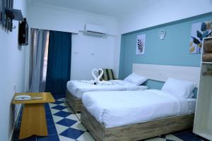 赫尔格达Lamera Hotel的酒店客房设有两张床和一张桌子。
