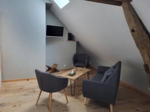 圣艾尼昂La petite maison的客厅配有桌子和两把椅子