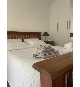 WansteadNewly built modern flat at London Gants Hill Station near Ilford的一张带白色床单和毛巾的床