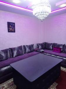伊夫兰APPARTEMENT AMIRA iFRANE的客厅配有紫色沙发和吊灯。