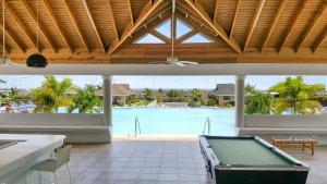 欧丘里欧Casa Maurice Ocho Rios Villa的一个带游泳池的房间中间的一张台球桌