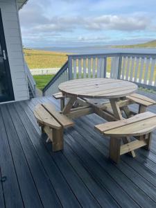 勒威克Wasterview, Central Mainland, Ideal base的木制野餐桌和甲板上的长椅