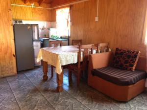 里坎雷Cabañas melinka的厨房配有桌椅和冰箱。