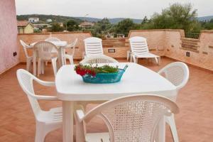 皮诺港Casa vacanza "Maestrale "的庭院里的白色桌椅