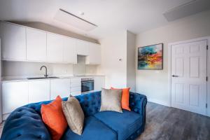 兰卡斯特Dalton Sq Apartment 2的厨房配有蓝色沙发,设有白色橱柜