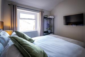 兰卡斯特Dalton Sq Apartment 2的卧室配有带枕头的白色床和窗户。