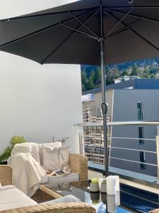 别拉什尼察Inverno Apartments Bjelašnica的坐在天井顶部的一把黑伞