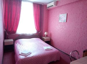 HryshkivtsiГотель "У Свата" Гришківці Бердичівський р-н的粉红色的卧室设有床和窗户