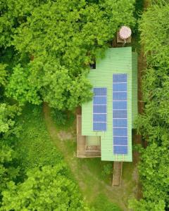 UsiacuríAnkua Eco Hotel的享有绿色建筑的顶部景色,设有蓝色太阳能电池板