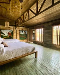 UsiacuríAnkua Eco Hotel的木制客房内的一间卧室配有一张大床