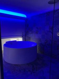 卡塔尼亚SUITE Nobile的一间带浴缸的浴室,享有蓝色的灯光