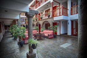 库斯科Munay Wasi Inn的一座庭院,里面设有长沙发和盆栽植物
