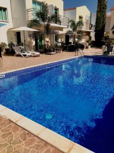 帕福斯Estia Luxury Maisonette的大楼前的大型蓝色游泳池