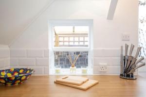Stoughton3 Bed House/Garden/Wi-Fi/Parking/Central Location的厨房配有木桌和窗户。