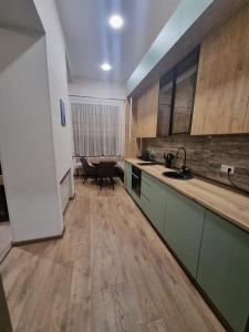 库塔伊西Nino's Cosy Apartment的厨房铺有木地板,配有橱柜和水槽。