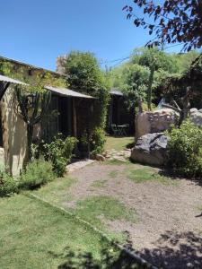 查克拉斯德科里亚Casitas del Cerro的一座带房子的花园和一个草地庭院