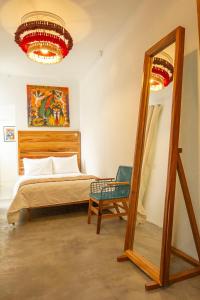 墨西哥城NaNa Vida CDMX的一间卧室配有一张床、镜子和椅子