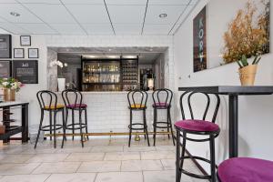 胡迪克斯瓦尔胡迪克贝斯特韦斯特酒店的餐厅内带紫色凳子的酒吧