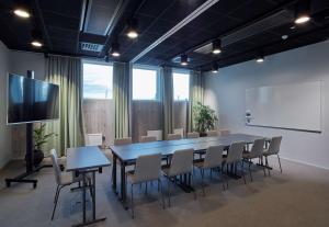 阿兰达Scandic Arlandastad的一间会议室,配有桌椅和屏幕