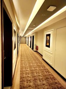 拉合尔Best Western Premier Hotel Gulberg Lahore的地板上铺着地毯的长走廊