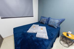 雅乌Jahu Center Plaza Flats的客房设有一张带蓝色床单的床和一台电视。