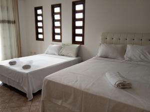 圣塞巴斯蒂安Casa da Fê的两张睡床彼此相邻,位于一个房间里