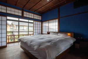 金泽Kenrokutei Oyado的一间卧室设有一张蓝色墙壁的大床