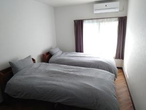 白滨Albany inn Shirahama アルバニーイン白浜的卧室设有两张床,带窗户