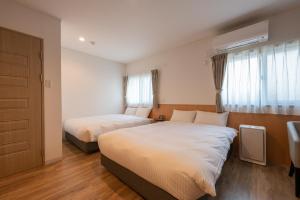 SakaiHOTEL R9 The Yard Sakai的酒店客房设有两张床和窗户。