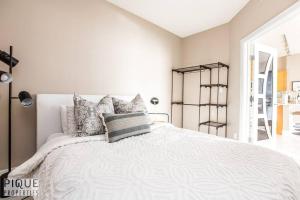 埃德蒙顿Luxury Downtown Suite, River Valley View, Patio & BBQ, Sleeps 4的卧室配有白色的床和枕头。