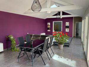 CessieuLe SPA de l Albizia的一间拥有紫色墙壁和桌椅的用餐室