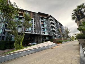 他朗Phuket apartment surin beach的一个大建筑前的一条空的街道