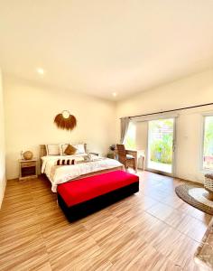 孟威Agung Wiwin Homestay & Restaurant的一间卧室配有一张大床和红色长凳