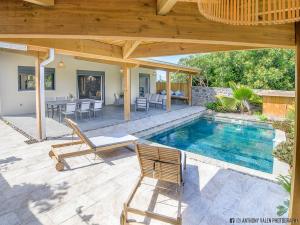 圣路易斯Villa Fleur de Jade的一个带游泳池和木制凉亭的庭院