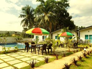 阿姆波尔White Truffle Resort, Arambol的游泳池旁带桌子和遮阳伞的天井