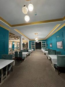 奎兹洛达Гостиница Селена的一间拥有蓝色墙壁和白色桌椅的用餐室