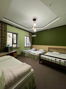 奎兹洛达Гостиница Селена的带绿色墙壁的客房内的三张床