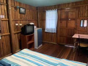 王南安科บ้านวนัชชา รีสอร์ท的一间卧室配有一张床、一台电视和一张桌子