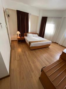 诗巫Kawan Hotel的一间卧室设有一张大床,铺有木地板。