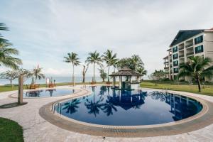 哥打京那巴鲁婆罗洲海滩别墅的一个带凉亭和棕榈树的度假游泳池