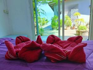 班柯木柯木海景简易别墅旅馆的两朵红花坐在床上