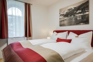 米特尔巴赫Konrad-Haus - DorfResort Mitterbach的卧室配有一张带白色和红色枕头的大床