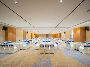 南宁南宁江南智选假日酒店的一个带白色桌子和蓝色椅子的大型宴会厅