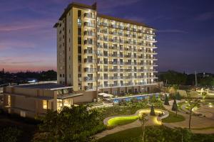 大雅台Quest Hotel Tagaytay的一座大型酒店建筑,晚上有庭院