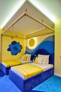 布加勒斯特Vilacrosse Boutique Inn的黄色和蓝色的客房内的两张床